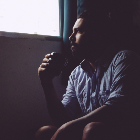 person drinking coffee looking out of a window